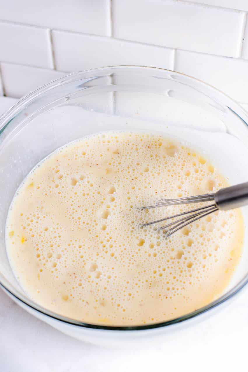 Egg custard mixture in bowl, ready to pour over bread pieces