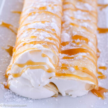 Three crepes on a plate filled with a cream cheese filling.