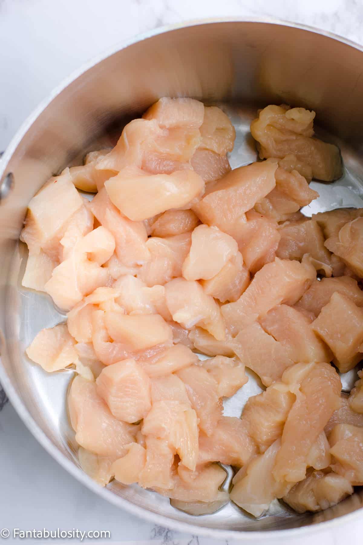 Raw chicken pieces in soup pot