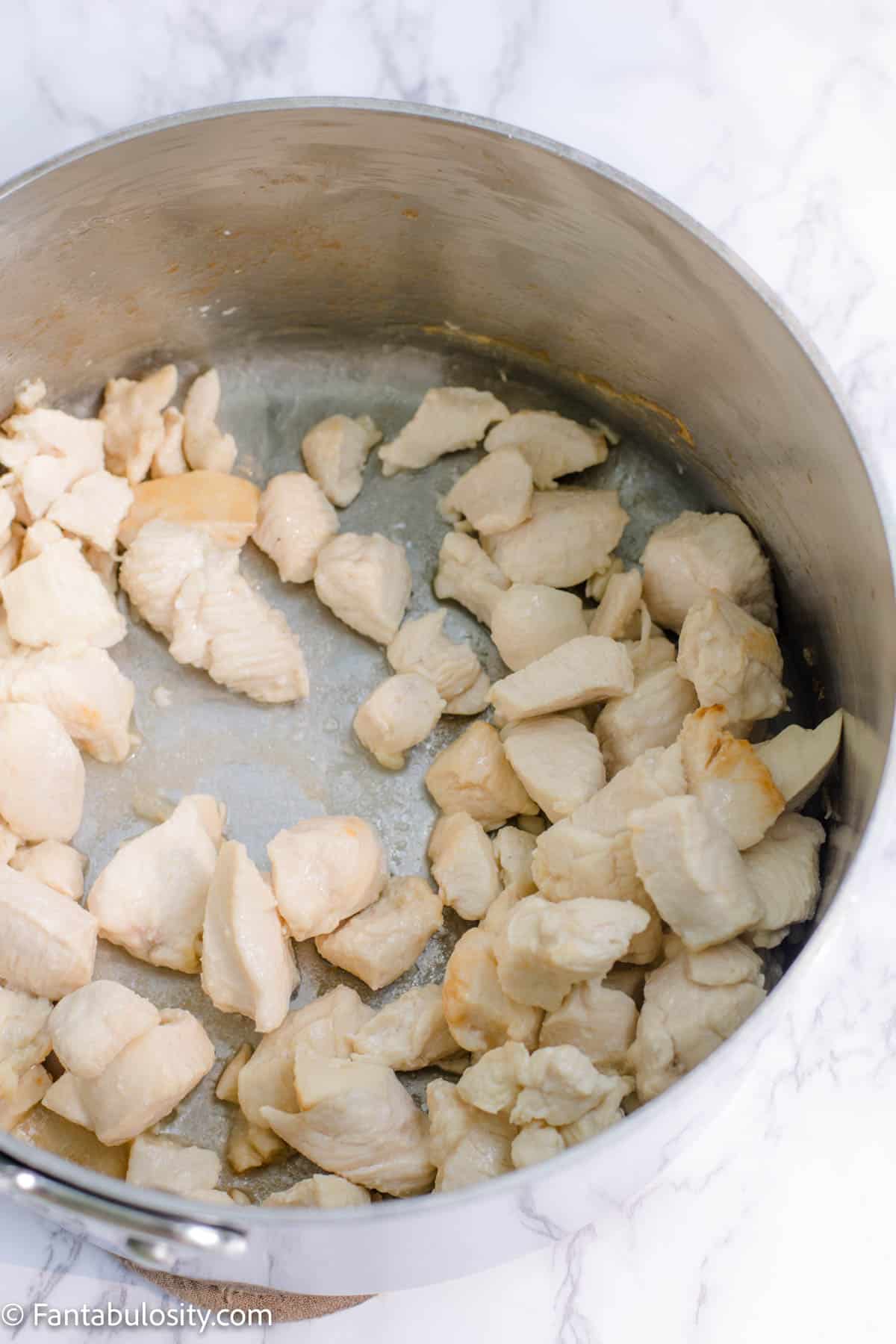 Cooked chicken pieces in soup pot