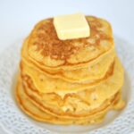 Butternut Squash Pancakes stacked with butter on top.