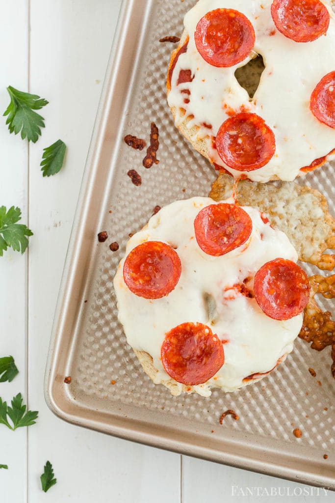 Pizza bagels with pepperoni on a baking sheet