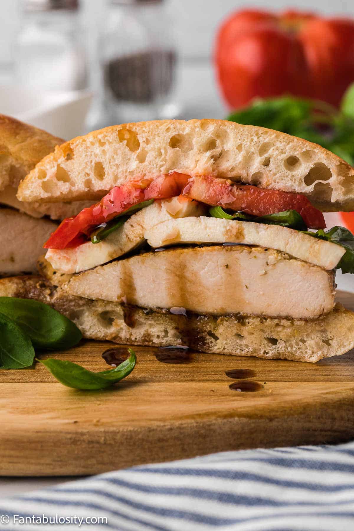 Chicken caprese sandwich sliced in half.