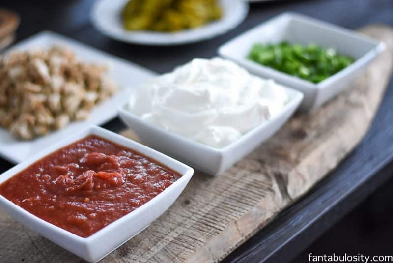 White bowls filled with salsa, sour cream, green onions