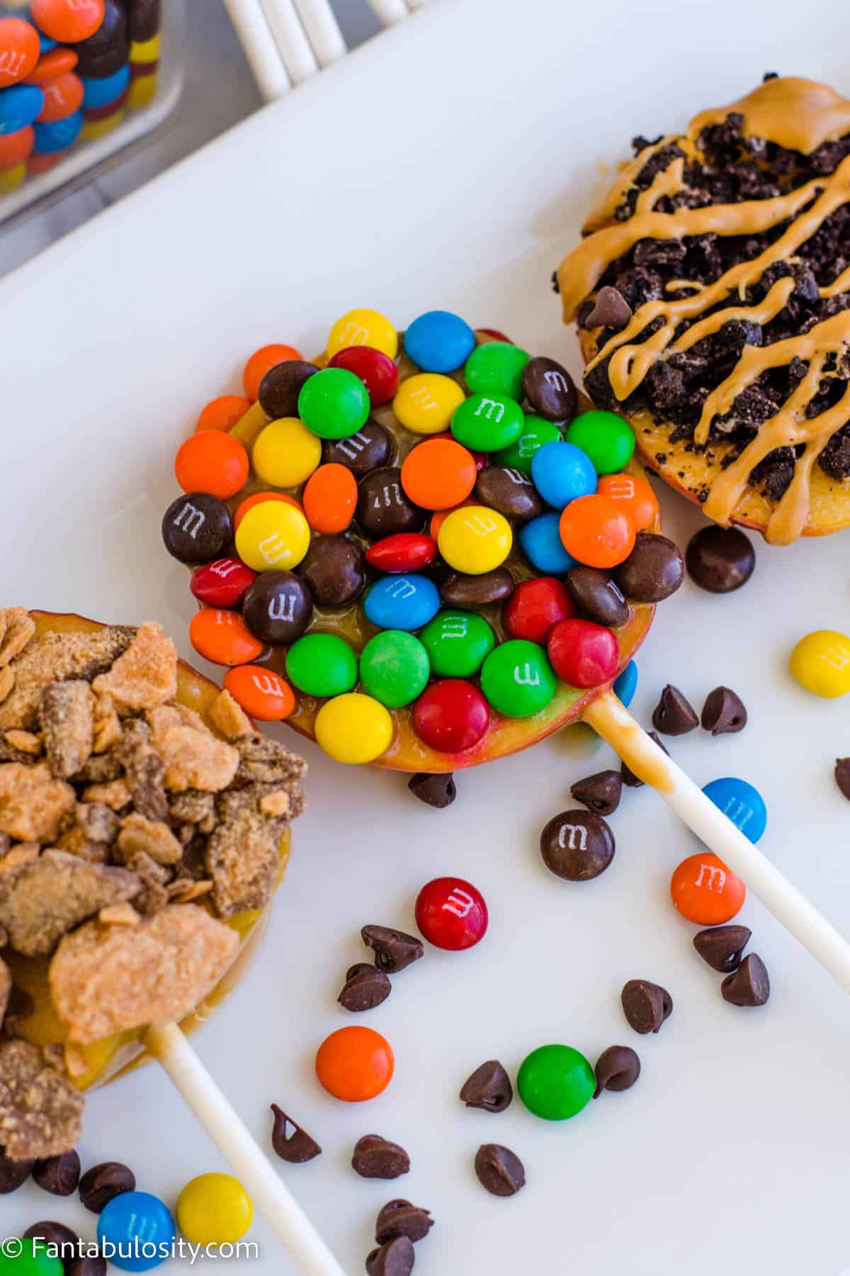 caramel apples on a stick, covered in candy