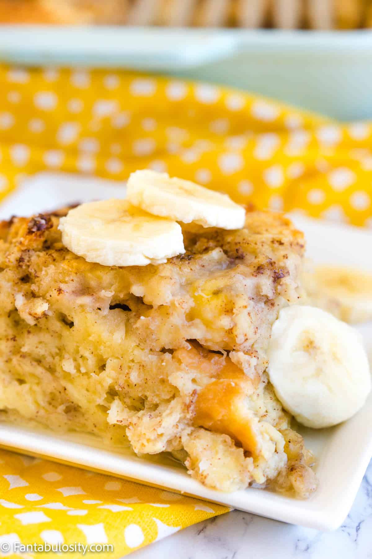 Slice of banana bread pudding on white plate