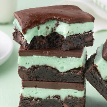 Stack of mint chocolate brownies with green background.