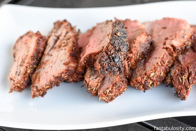 Sliced beef tenderloin on white platter