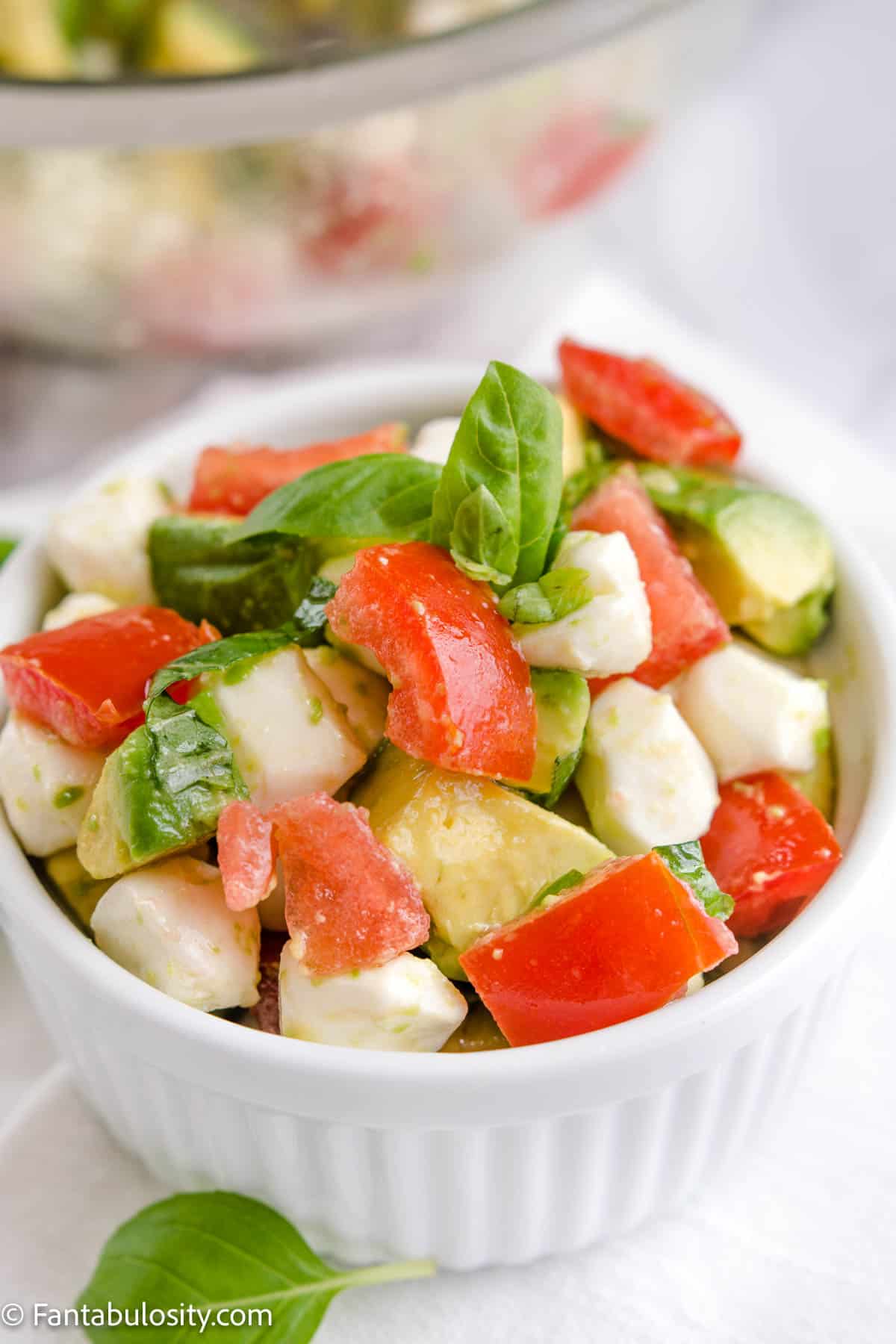 avocado tomato mozzarella salad in white bowl