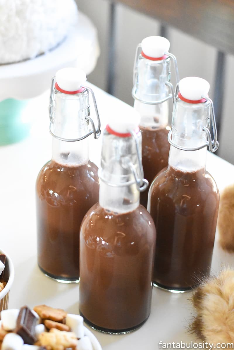 A Camp-In Sleepover! Chocolate Milk in fun glass bottles for a Camping Sleepover Birthday Party! How fun is this! It's all so cute!!! Camping Sleepover Birthday Party Ideas! Pottery Barn Kids, fake fire, tents, sleeping bags, fire birthday cake, kaleidoscope, birthday banner. 