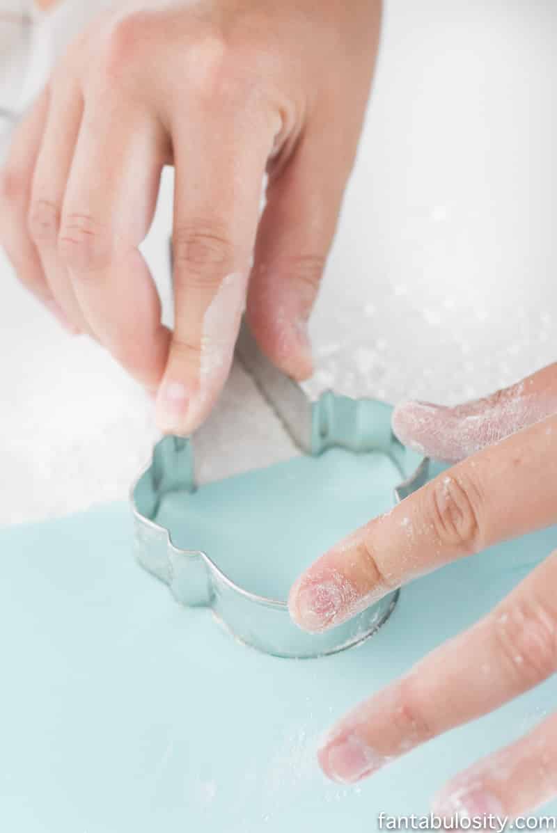 Using a cookie cutter to cut fondant to decorate ice cream cone cookies