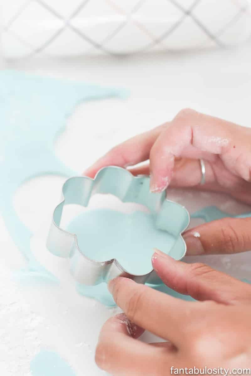 Using a cookie cutter to cut fondant to decorate ice cream cone cookies