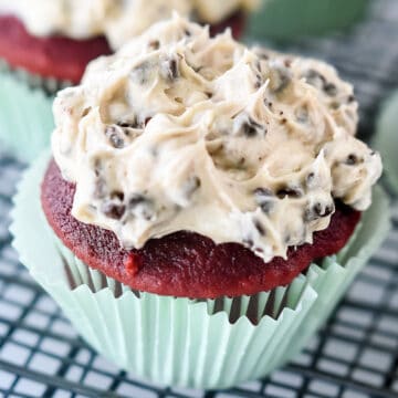 Red velvet cupcake with chocolate chip frosting.