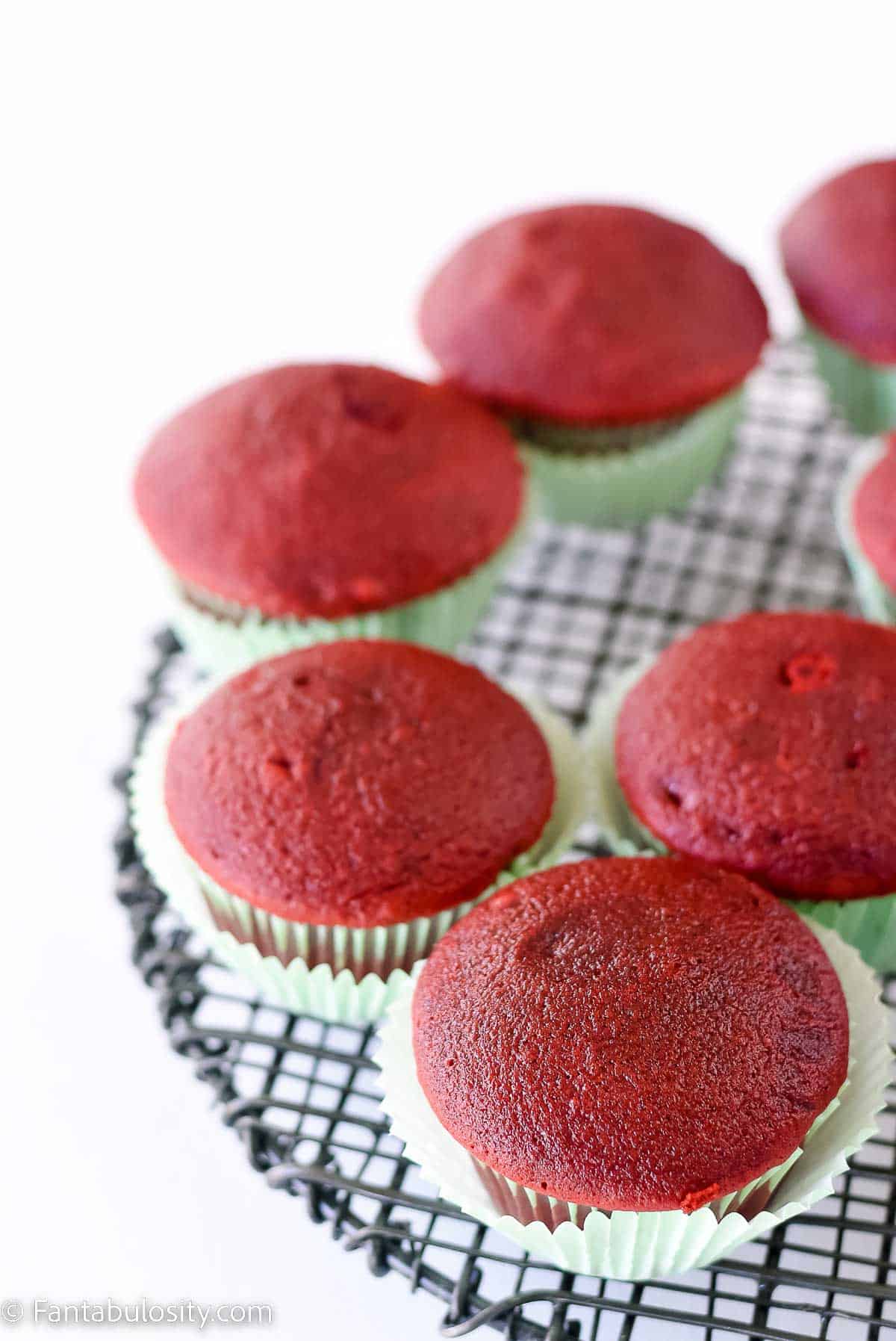 Red velvet cupcakes on cooling rack.