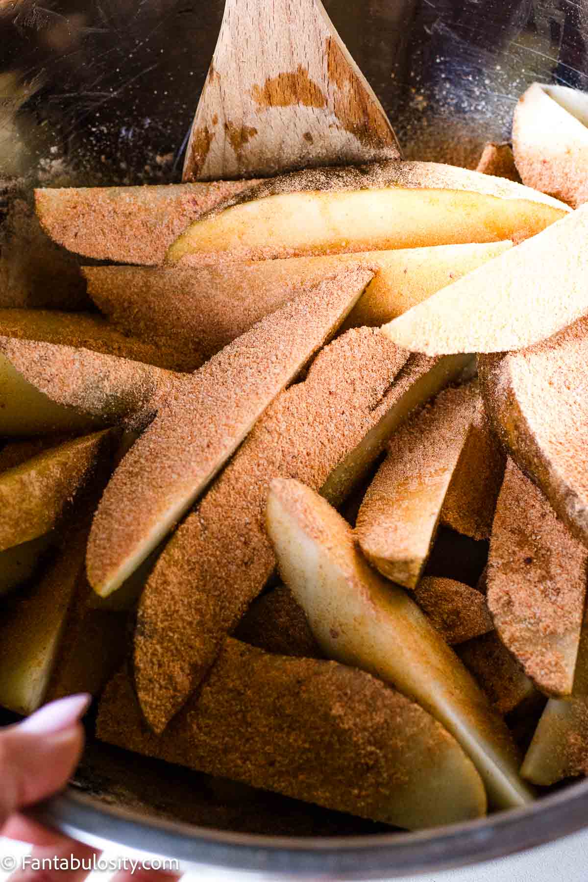 Potato wedges in large bowl, topped with Fiesta ranch seasoning.