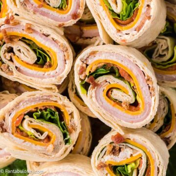 Close-up of pinwheel sandwiches stacked on top of one another.