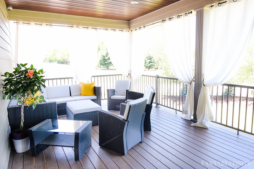 Craftsman Home Patio. Back patio design with sectional and curtains. White and yellow pillows - Fantabulosity Home Tour
