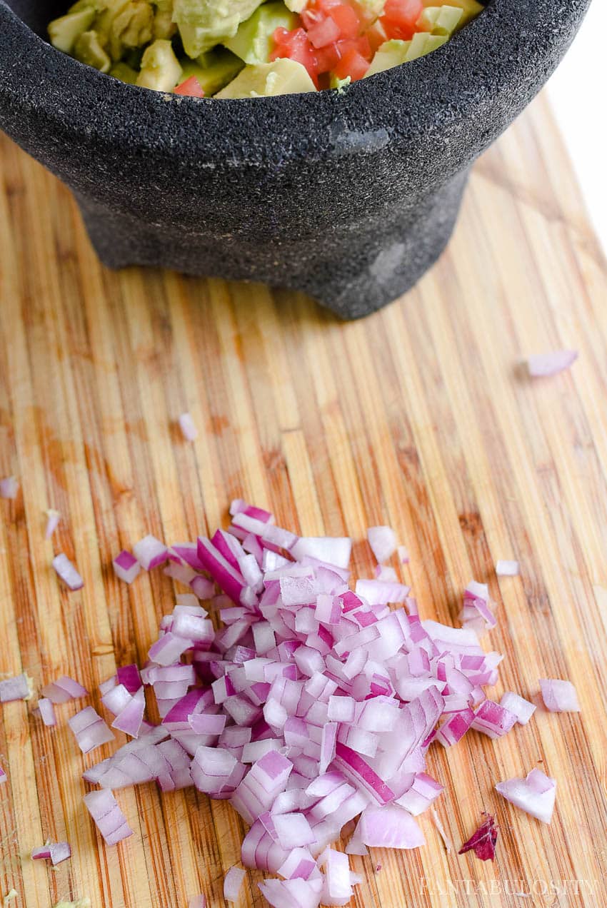 Dice red onion up for guacamole