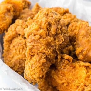 Close up of southern fried chicken on white plate.