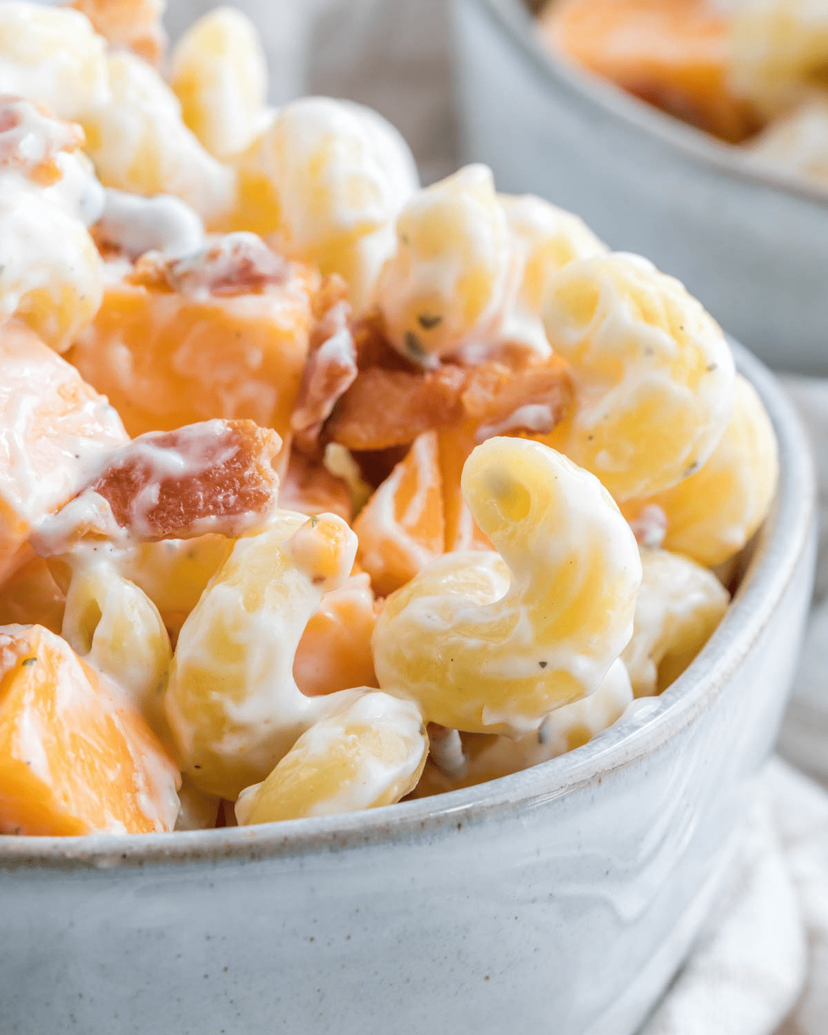 Ranch Pasta Salad in a white bowl with bacon crumbles