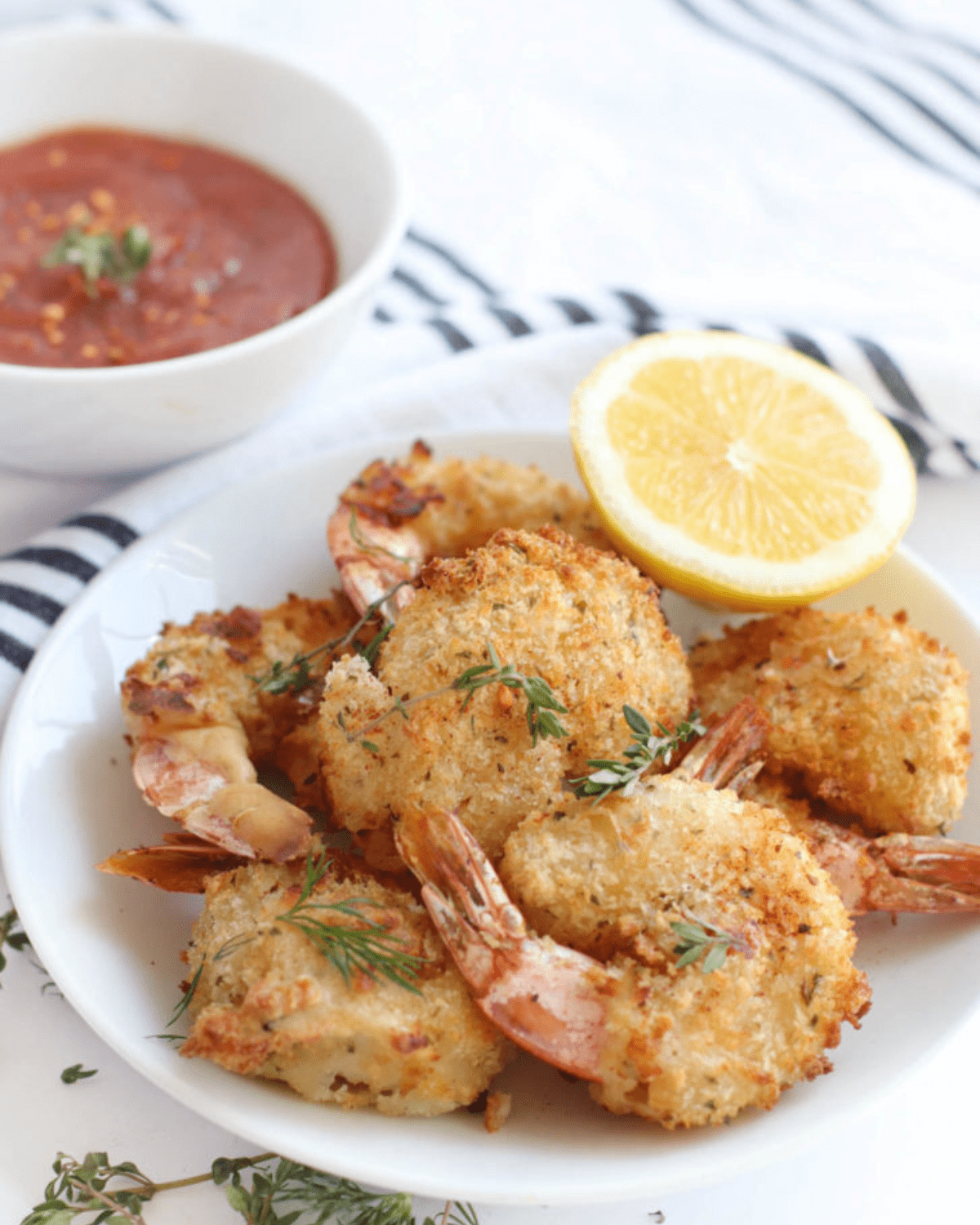 Air Fryer Breaded shrimp on a plate with lemon and cocktail sauce