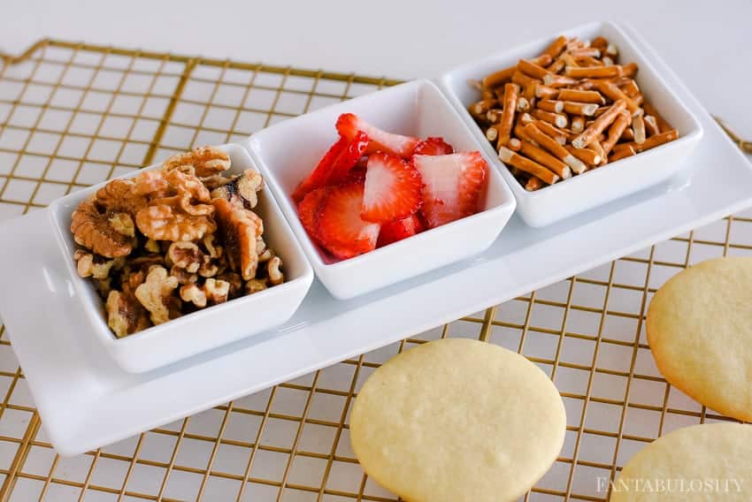 Strawberries, walnuts, and pretzels on top of sugar cookies