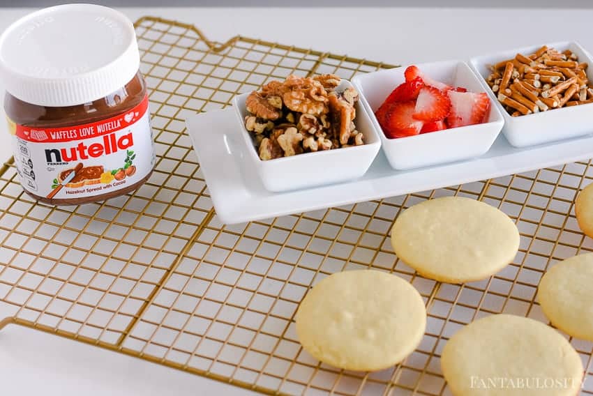 Strawberries, walnuts, and pretzels on top of sugar cookies