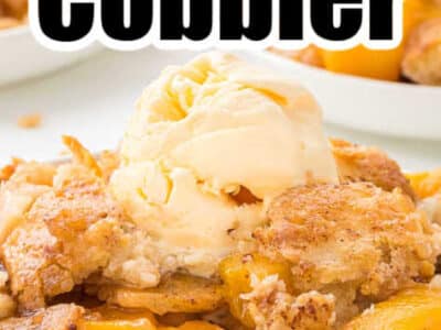 A serving of peach cobbler made with Bisquick on a white plate, that's topped with a scoop of vanilla ice cream.