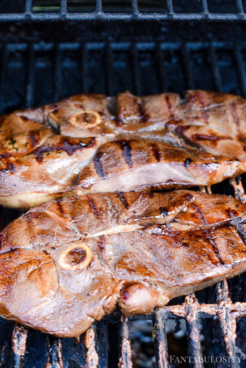 Marinated venison steak on grill.