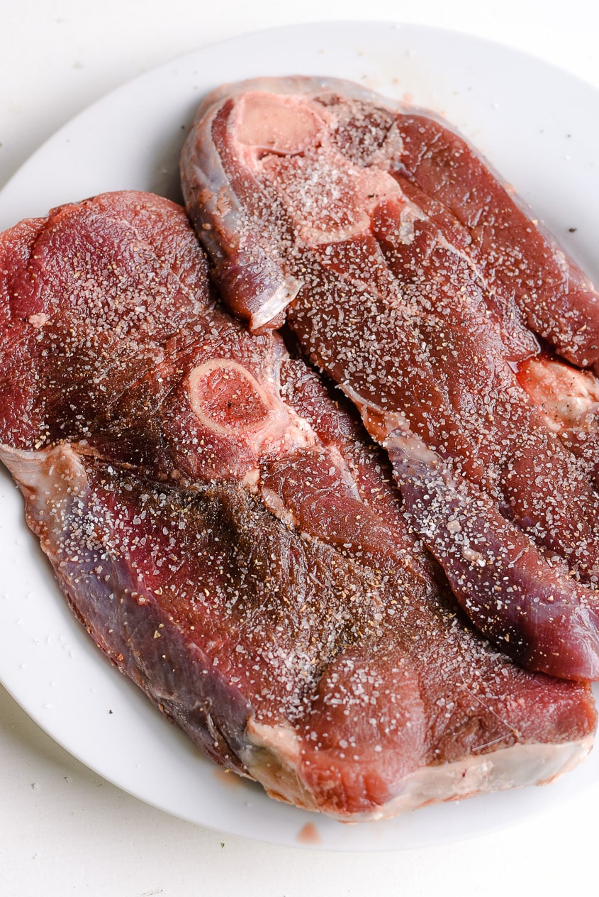 Season deer steak with salt and pepper