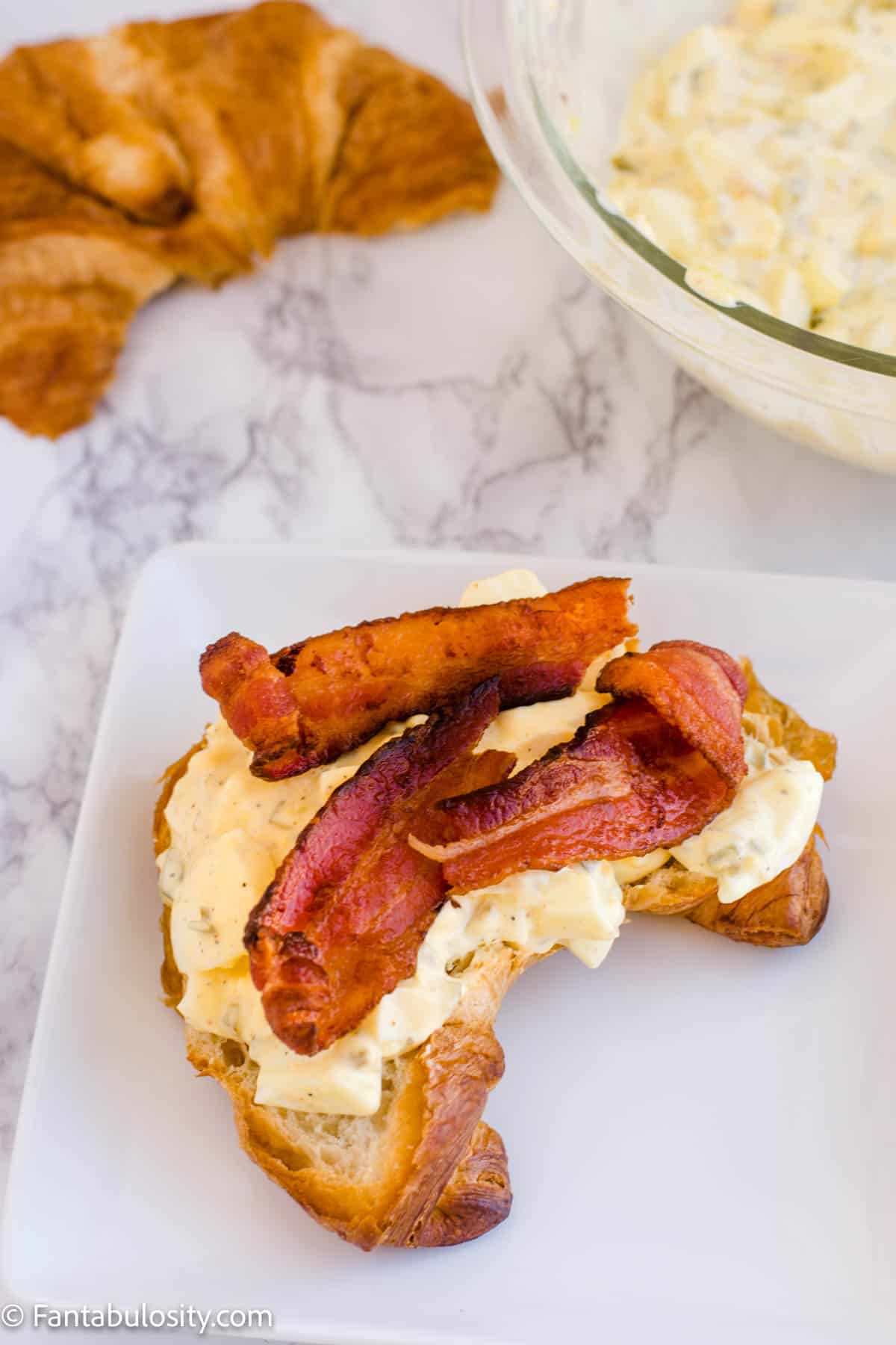 egg salad sandwich topped with bacon