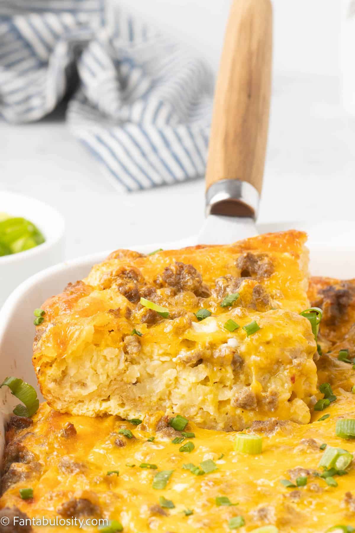 Sausage and Egg Casserole being lifted out of baking dish