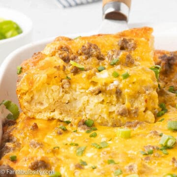 sausage and egg casserole being lifted out of baking dish