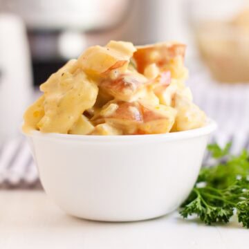 A bowl filled with a heaping serving of Amish Potato Salad.