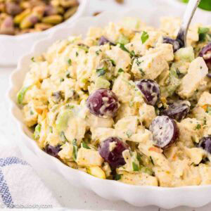 Curry chicken salad with grapes in a white bowl.