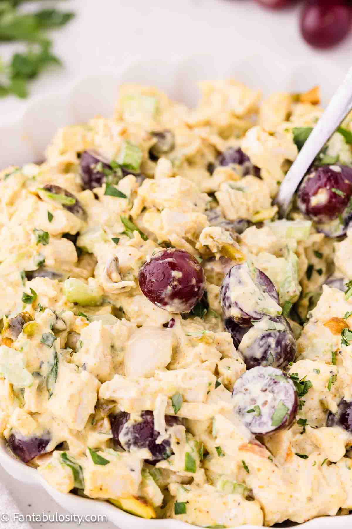 Curry chicken salad mixed together in mixing bowl.
