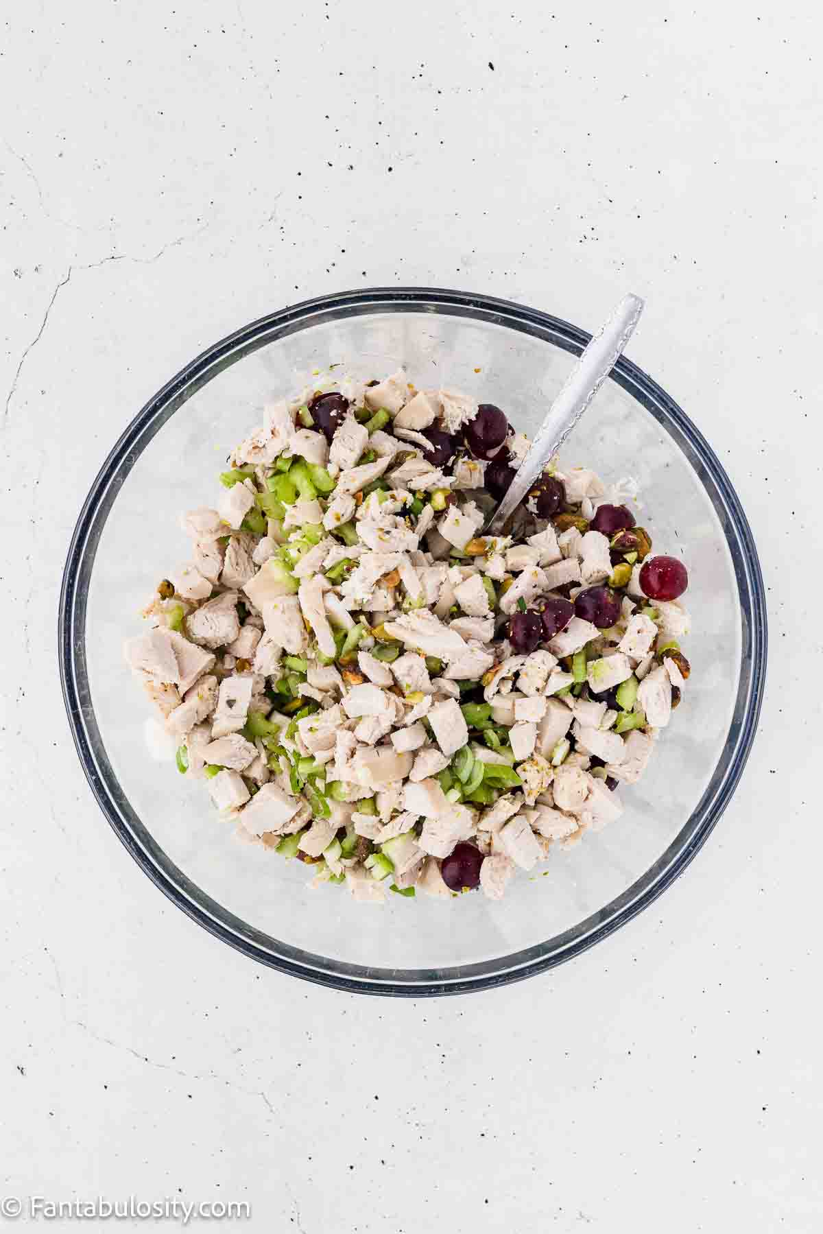 Chicken, celery, grapes in mixing bowl.
