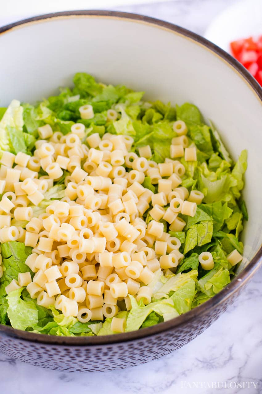 Ditalani pasta on top of lettuce in a salad bowl