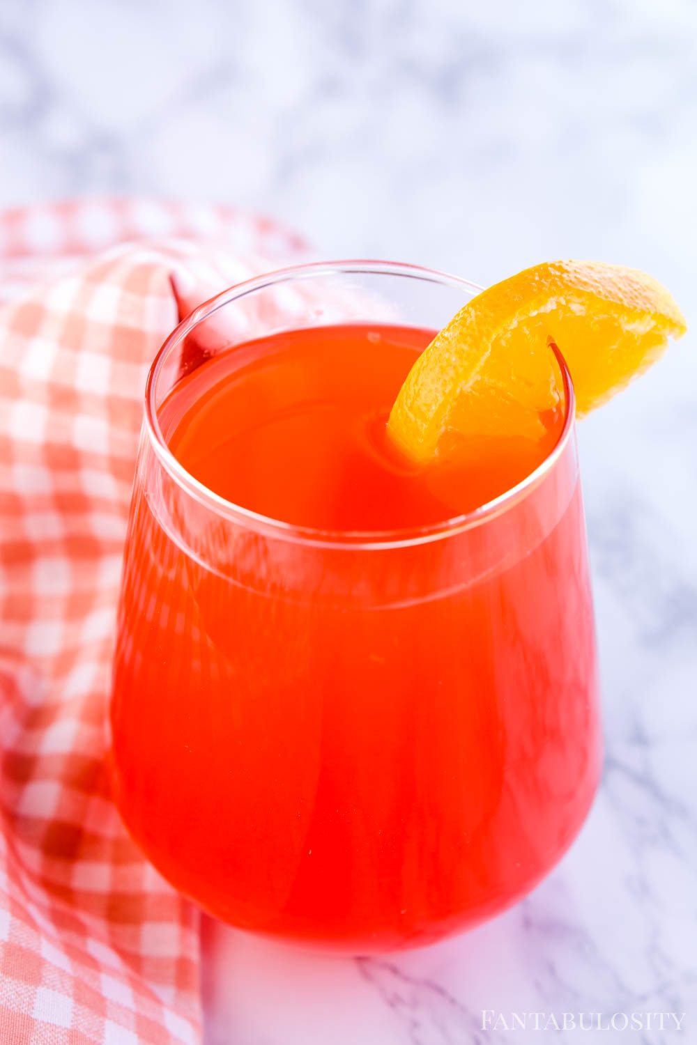 Red Fruit punch in glass with orange slice