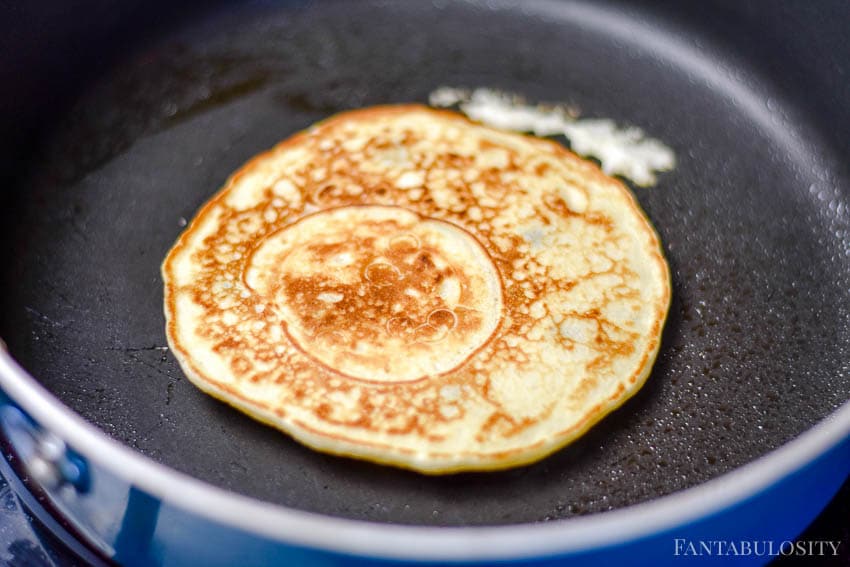 Cooking blueberry pancakes in a skillet on the stove