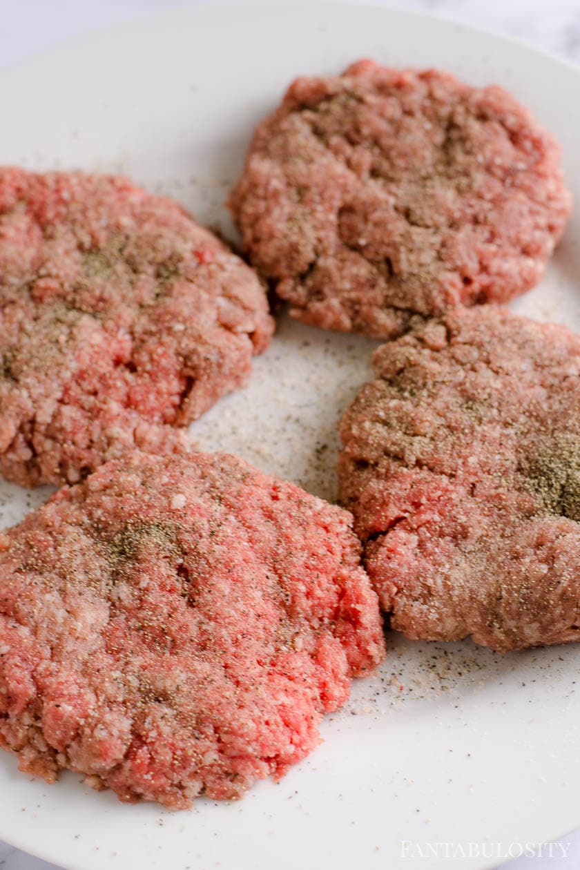 Seasoned hamburger patties with salt and pepper