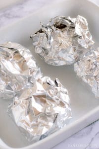 Wrap cheeseburger in aluminum foil and place in oven to steam