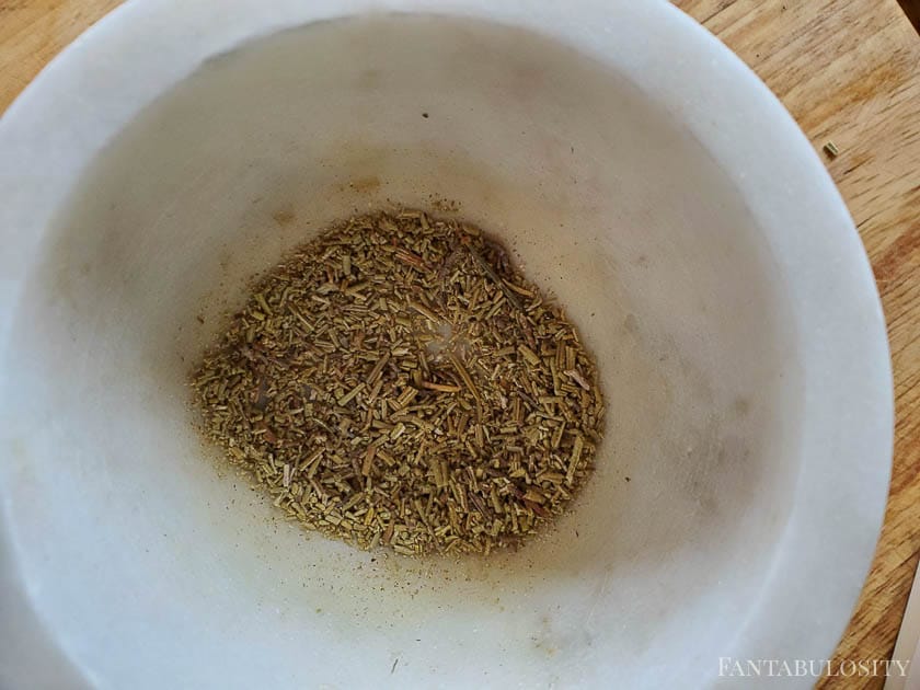 Crushed rosemary in a white bowl