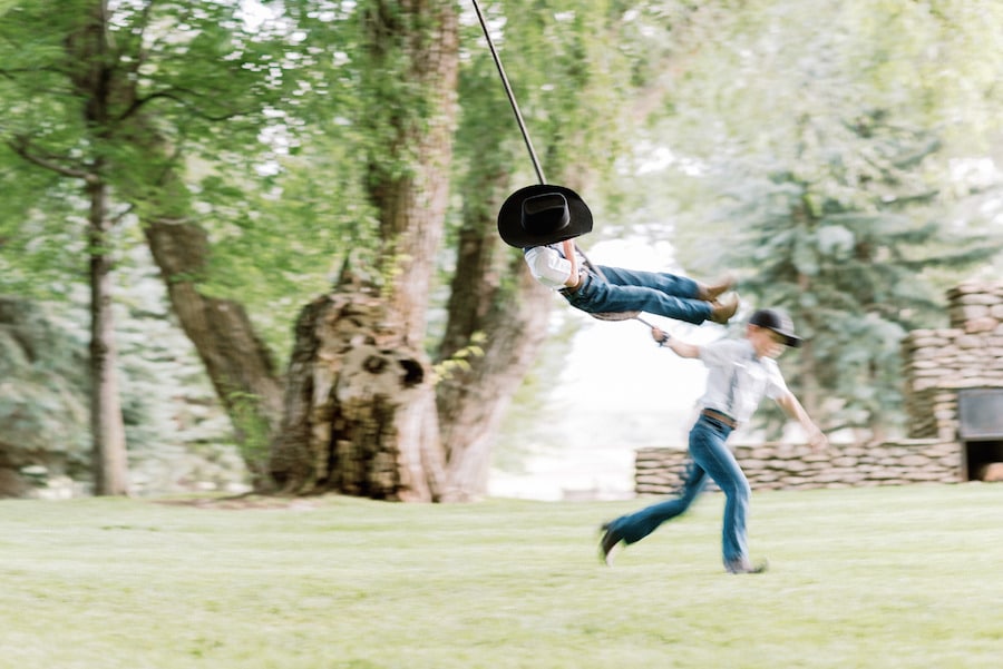 Two little boys playing on rope swing