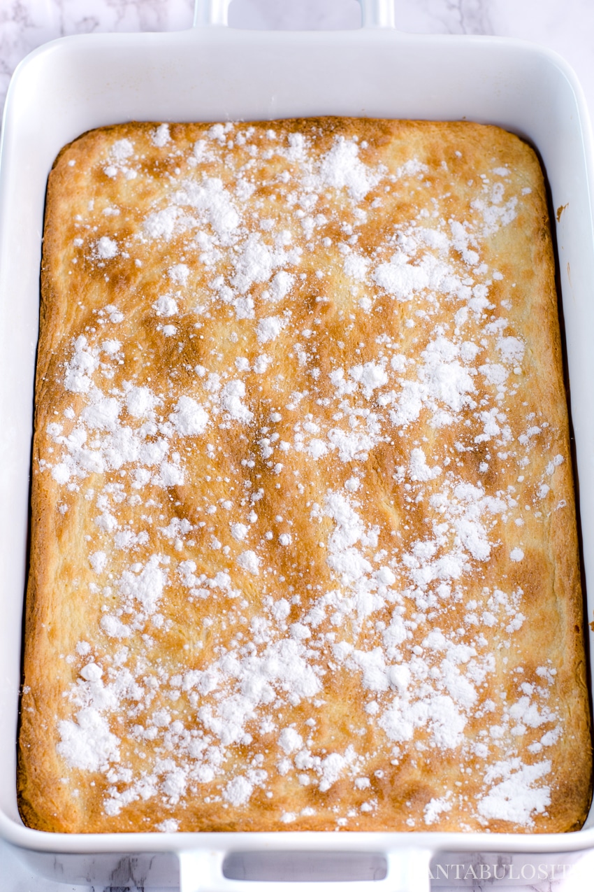 Sprinkle powdered sugar on top of gooey butter cake