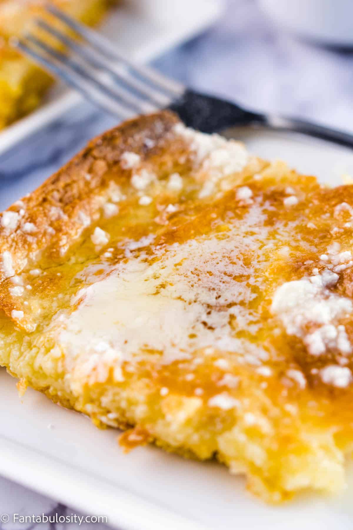 Close up of gooey butter cake slice on white plate