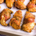 Smoked chicken tenders on parchment paper and baking sheet.