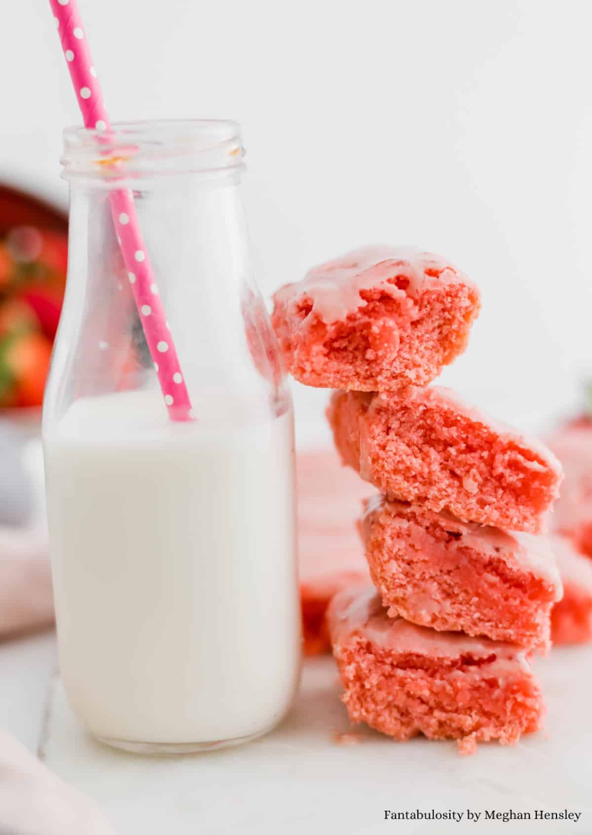Strawberry brownies, leaned up against a bottle of milk.