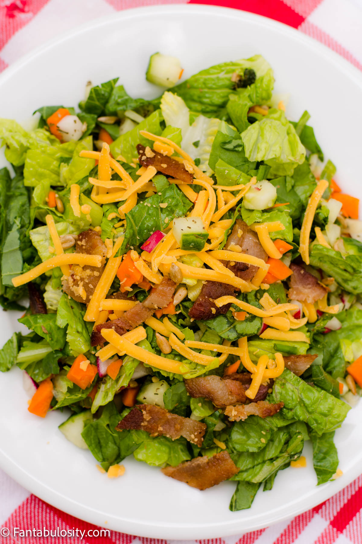 Dinner salad on white plate with red and white cloth