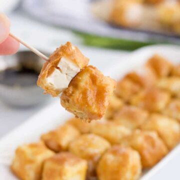 Two pieces of air fryer tofu on a toothpick.